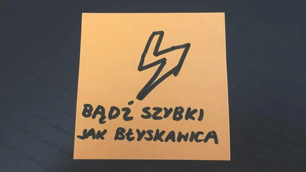 Pomarańczowa karteczka z błyskawicą i napisem Bądź szybki jak błyskawica